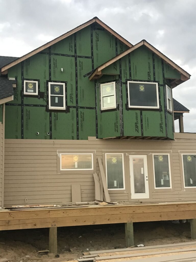 New roof, windows and lap siding on a raised coastal home by Cas and Cal Construction